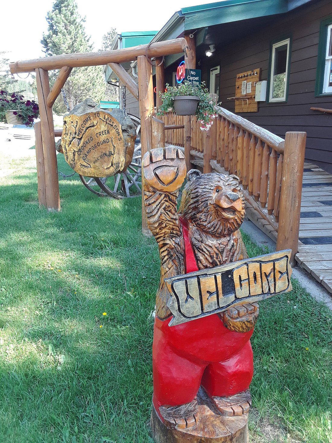 Wooden Bear holding welcome sign